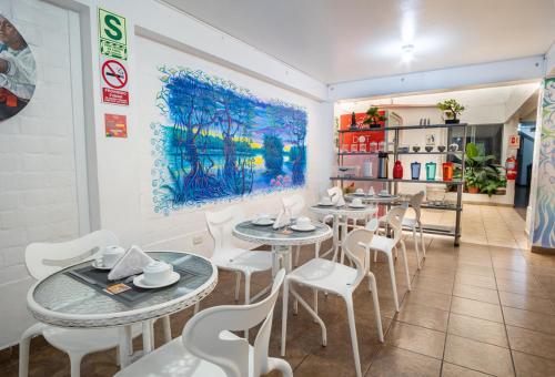 利马Magdalen House的餐厅设有桌椅,墙上挂有绘画作品