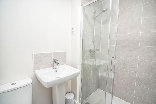 唐克斯特Solid Mirror Modern Riverside Home, Doncaster的白色的浴室设有水槽和淋浴。