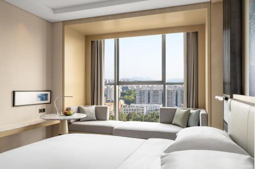 汕尾汕尾海丰万怡酒店的酒店客房设有一张床和一个大窗户