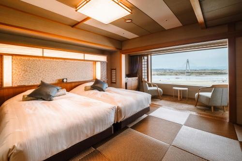 音更町十胜川温泉第一酒店的一间卧室设有两张床和大窗户
