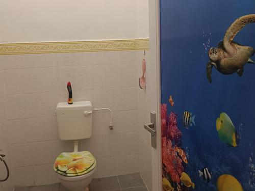 关丹AV HOMESTAY的浴室设有卫生间,墙上挂有恐龙