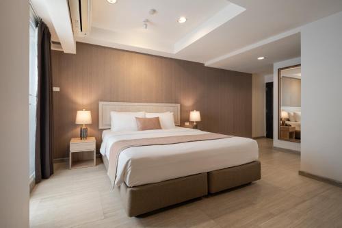 曼谷阿斯皮拉卢阿卢迪公寓的一间卧室配有一张大床和两盏灯。
