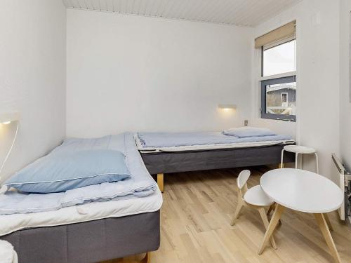 博托比Four-Bedroom Holiday home in Væggerløse 22的配有两张床铺的客房配有桌椅