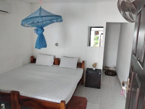 亭可马里Udayam guest的一间卧室配有一张带蓝伞的床