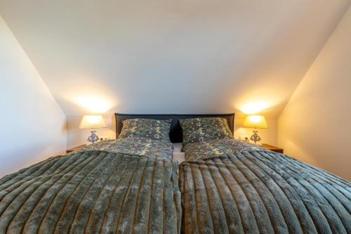 洛默Villa Heimathafen Rügen - Luxus gepaart mit Wellness的卧室内的两张床,配有两盏灯