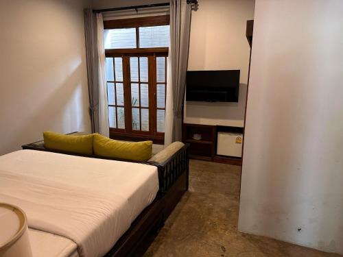 波普托Baan Yaimai Boutique Samui的一间卧室设有一张床、一台电视和一个窗口。