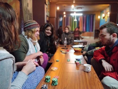 瑞诗凯诗Live Free Hostel Rishikesh的一群人坐在桌子旁玩多米诺骨牌