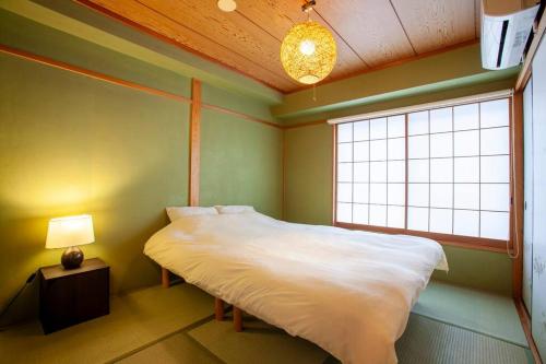 东京PREMIER suite Shinjuku West 3F 4F的一间小卧室,配有床和窗户