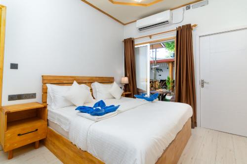 乌库拉斯Tropico villa的卧室配有白色床和蓝色弓