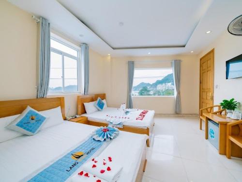 吉婆岛Lang Chai Hotel - Travel Agency的酒店客房设有两张床和窗户。