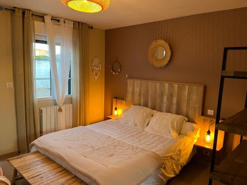 勒克罗图瓦La Rose des Vents的一间卧室设有一张大床和一个窗户。