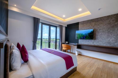 坎古ValStar Hotel Canggu的酒店客房设有一张大床和一台电视机。