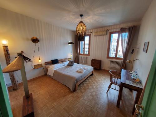 威尼斯Residenza La Veranda a Rialto的卧室配有床、桌子和窗户。