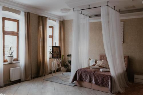 PitschenPrudentia Hotels Adler的一间卧室配有带窗帘的天蓬床