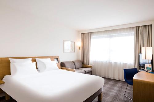 亚琛诺富特亚琛城市酒店的一张大白色的床,位于酒店客房内