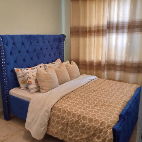ThikaVerona Apartments的卧室内的蓝色床头板