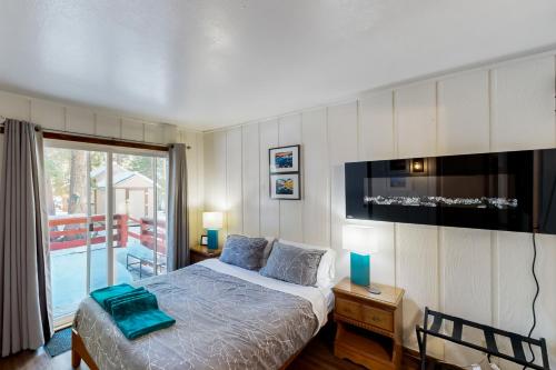 玛瑙湾Tahoe Twilight的一间卧室设有一张床、一台电视和一个阳台。
