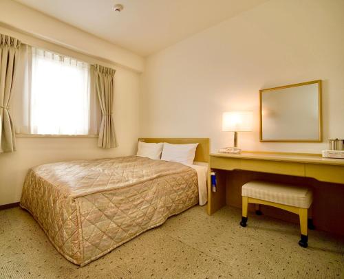 冈山Okayama Universal Hotel Annex 2的配有一张床和一张书桌的酒店客房