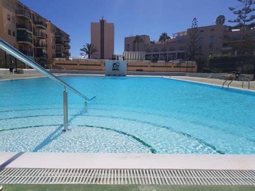 洛斯克里斯蒂亚诺斯Sun Apartment Cristimar (3 bedrooms)的一个大型蓝色游泳池,其建筑背景为: