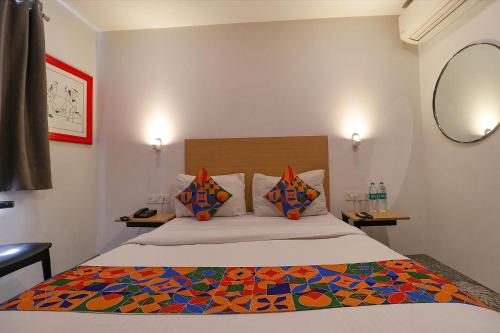 新德里FabHotel La Serene Punjabi Bagh的一间卧室配有一张带五颜六色棉被的床