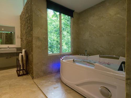 基图尔格勒棕榈石度假屋酒店的带浴缸和盥洗盆的大浴室