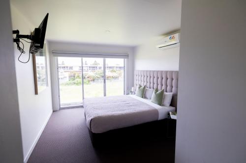 阿波罗湾阿波罗酒店的一间卧室设有一张大床和大窗户