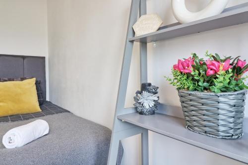 雷利Lavish Rayleigh Apartment - Small-Med dog OK的放在架子上的粉红色花瓶