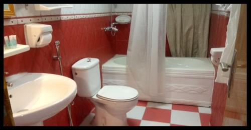 Al Masfalahفندق مشرق كدي的红色和白色的浴室设有卫生间和水槽