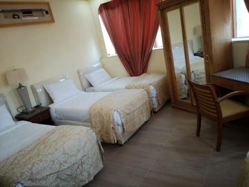 Al Masfalahفندق مشرق كدي的酒店客房,设有两张床和镜子