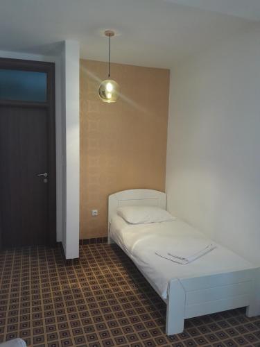 萨拉热窝Hotel PEKING的卧室配有白色的床和灯