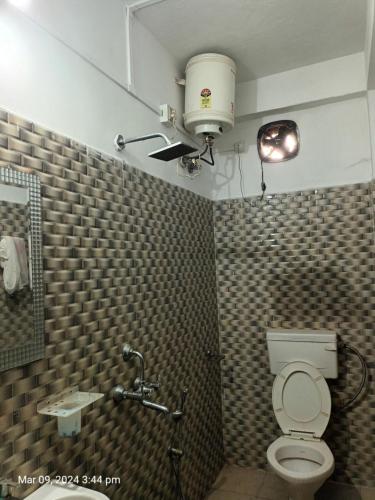 古瓦哈提Suryalaxmi guest house的一间带卫生间的浴室和天花板上的灯