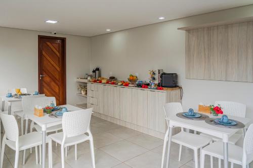 费尔南多 - 迪诺罗尼亚Pousada Tartarugas Marinhas的用餐室配有白色的桌子和白色的椅子