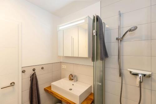 奥斯赛拜-屈隆斯博恩Möwen-Butze 8103 Yachthafenresidenz的白色的浴室设有水槽和淋浴。