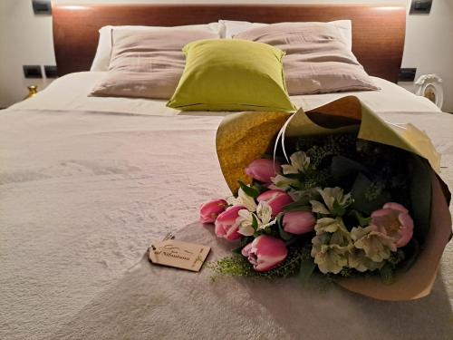 瓦雷泽Al Nifontano B&B - Ideal for Family or Couples - 2 Rooms - Lakeview的床上一束鲜花,上面有标签