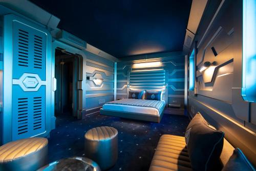 沙斯讷伊迪普瓦图Hôtel Station Cosmos的蓝色卧室,配有床和桌子
