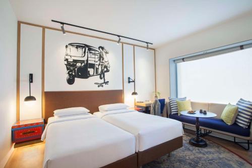 班加罗尔班加罗尔MG路凯悦中心酒店的一间卧室配有两张床、一张桌子和一张沙发