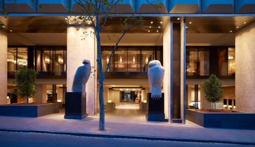 墨尔本墨尔本君悦酒店的两座鸟雕像在一座建筑的中间