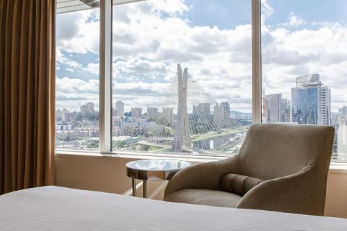 圣保罗圣保罗凯悦酒店的卧室配有一张椅子,位于大窗户前