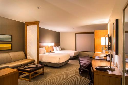 夏洛茨维尔夏洛茨维尔凯悦嘉轩酒店的酒店客房,设有两张床和一张沙发