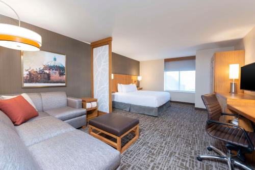 皇家橡Hyatt Place Detroit/Royal Oak的酒店客房设有一张沙发和一张床