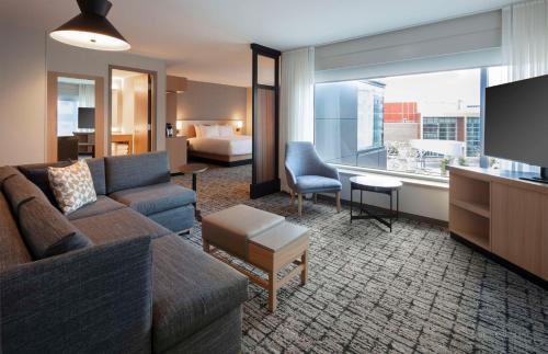 蒙克顿Hyatt Place Moncton-Downtown的带沙发的客厅和带沙发床的房间