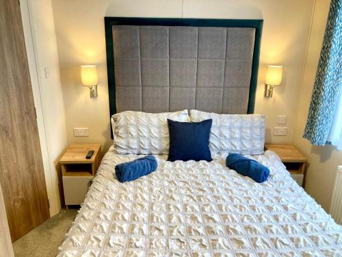 布德102, Duckpool Lodge的一间卧室配有一张带蓝色枕头的大床