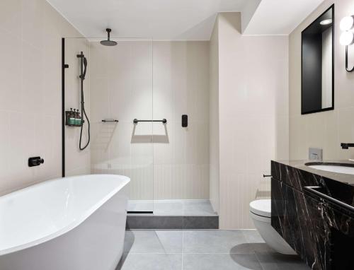 伦敦伦敦假日酒店 - 斯特拉特福市的带浴缸、卫生间和淋浴的浴室。