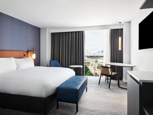伦敦伦敦假日酒店 - 斯特拉特福市的配有一张床和一张书桌的酒店客房