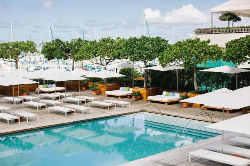 檀香山Hilton Vacation Club The Modern Honolulu的一个带躺椅和遮阳伞的室外游泳池