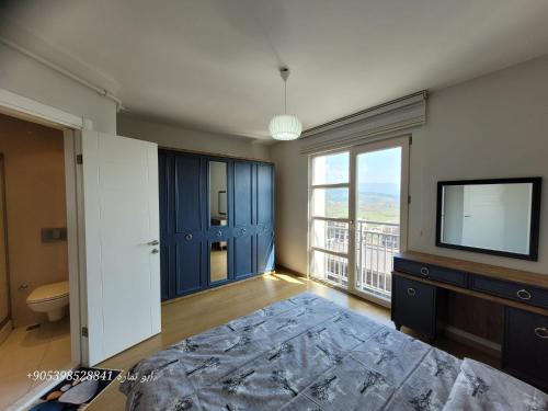 伯萨Apartment Resort Bursa的一间卧室设有一张床、一台电视和一个窗口。