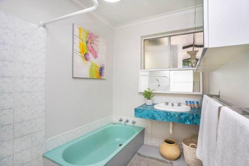 珀斯Vivid house in Wembley Downs的浴室配有蓝色浴缸和水槽