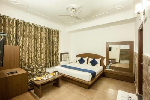 格德拉Hotel Katra Residency的酒店客房,配有床和镜子