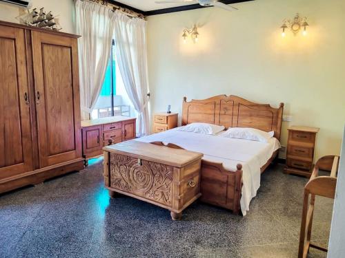 科伦坡VILLA COLOMBO7 5BR HOLIDAY HOME UP to 10 Guests的一间卧室设有一张大型木床和一个窗户。