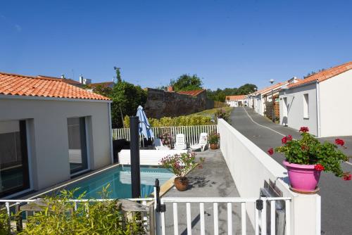 莱萨布勒-多洛讷海洋公寓酒店的一座别墅,设有游泳池和白色的围栏